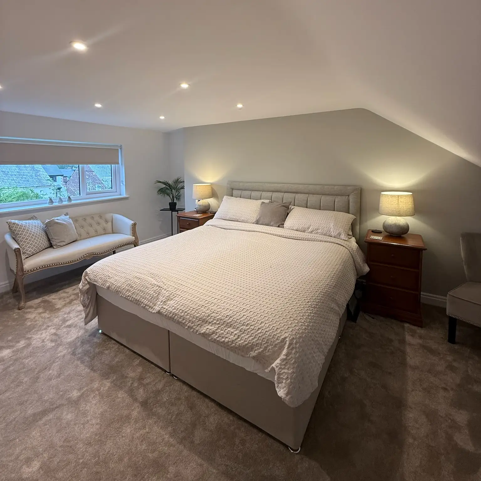 Garage converted into a double bedroom with carpet and soft lighting